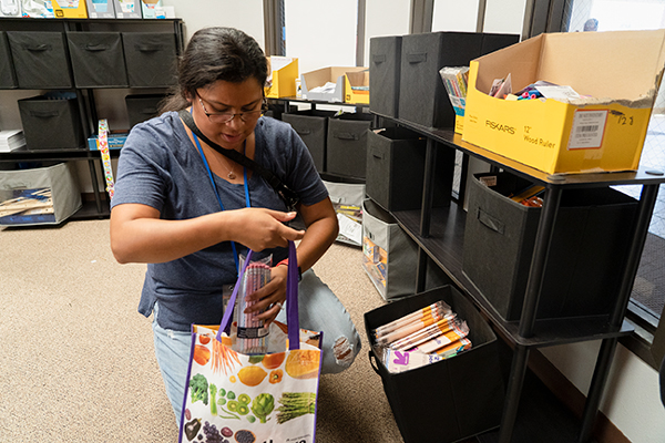 An APS associate is seen taking supplies from the educator emporium 